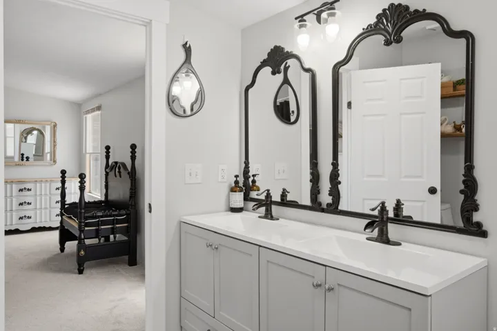 Double vanity with light gray cabinetry, white countertops, and matte black fixtures