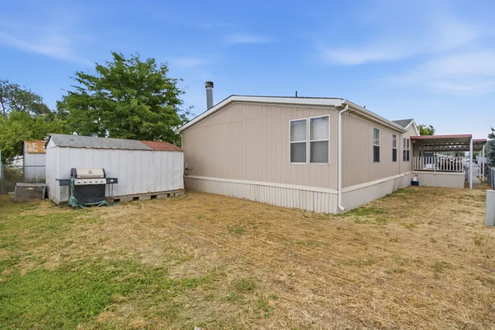Spacious backyard featuring a storage shed, covered porch, and partial fencing