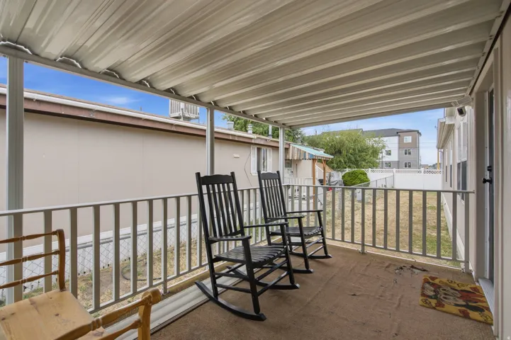 Covered patio area featuring a corrugated metal roof and white railings