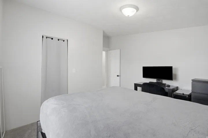 Bedroom featuring light gray wall paint, a flush-mount ceiling light fixture, and gray carpet flooring
