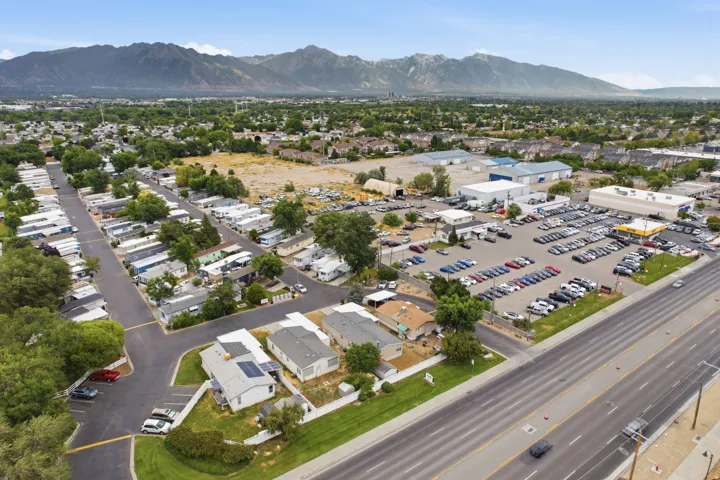 Aerial perspective showcasing an expansive property with multiple structures, paved roads, and a large commercial lot