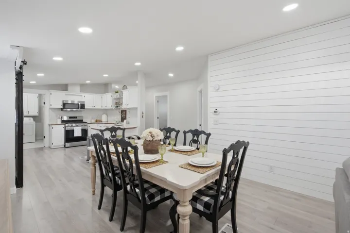 Dining area featuring a shiplap accent wall and recessed lighting