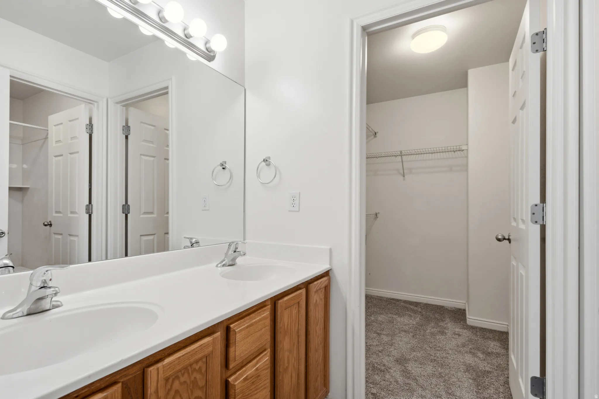 Bathroom featuring a double vanity with two undermount sinks and chrome faucets