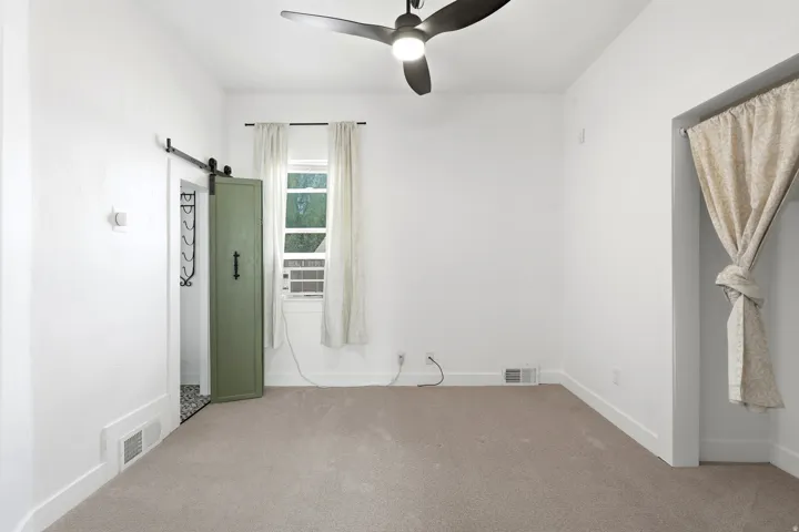 Neutral carpeted flooring with white baseboards
