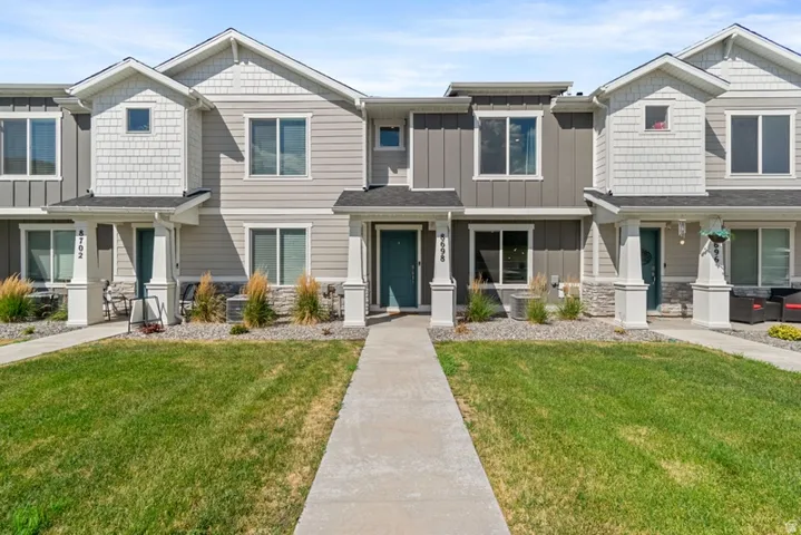 Modern townhome exterior featuring multi-toned siding, white trim, and a prominent front entrance