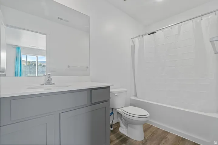 Modern bathroom featuring a single vanity with a light gray cabinet and white countertop, integrated sink, and chrome faucet