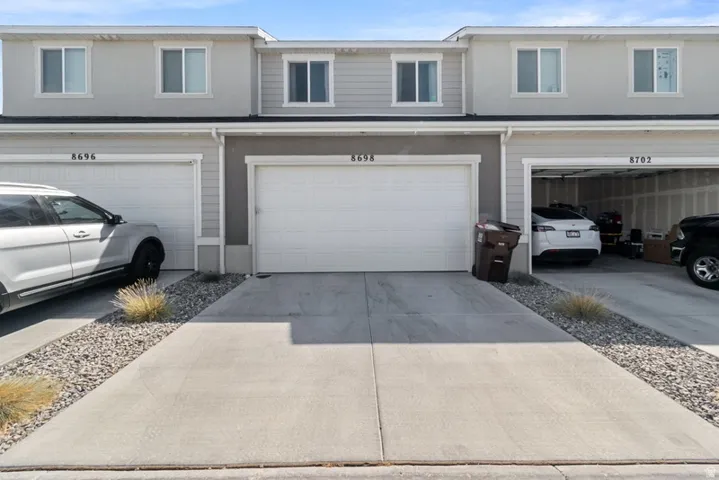 Light gray townhouse exterior featuring white trim and multiple windows