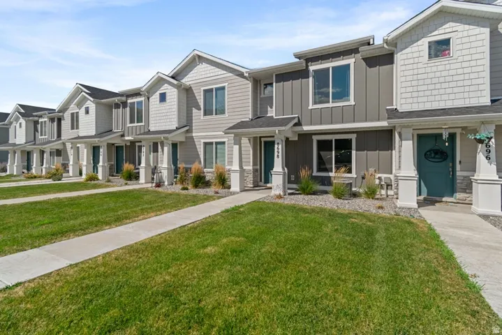 Modern townhome exterior featuring a combination of horizontal siding, vertical board and batten, and decorative shake siding