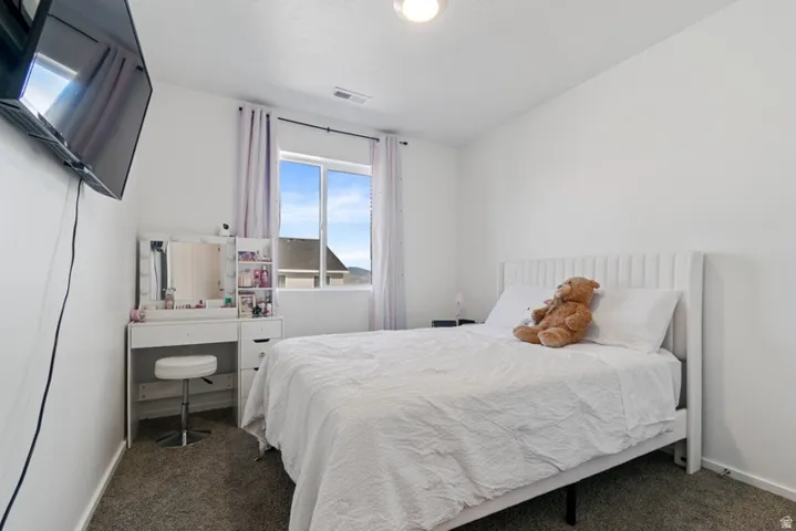 Bright interior space featuring a window with exterior views, light-toned walls, and neutral carpet flooring