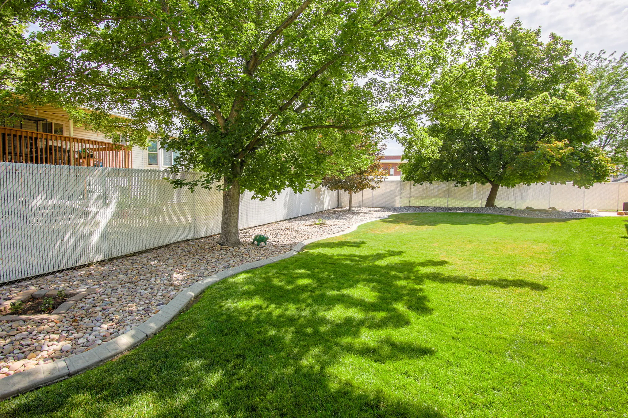 Expansive lawn area with mature trees providing shade