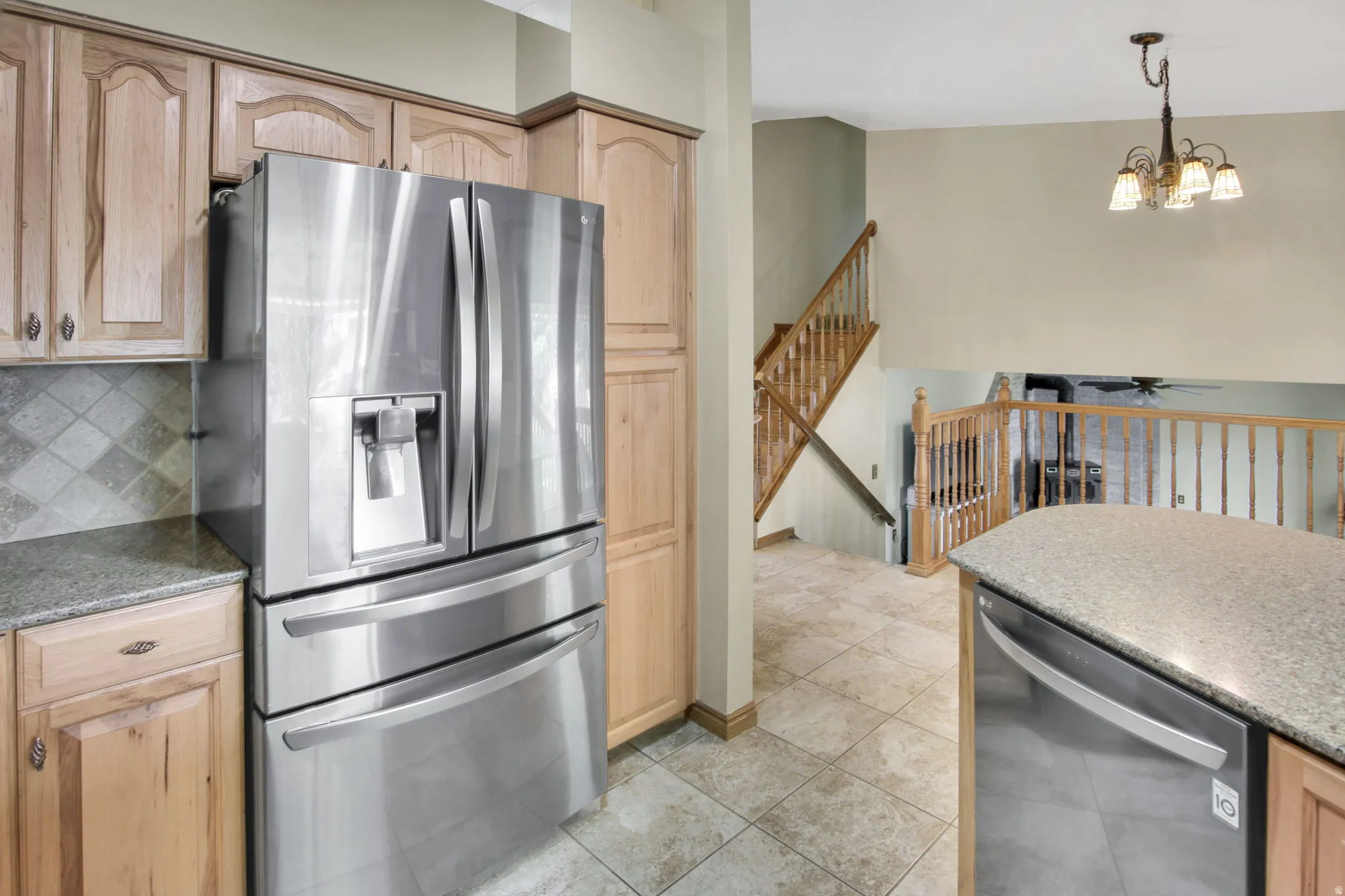 Kitchen featuring stainless steel appliances, light wood cabinetry, and granite countertops