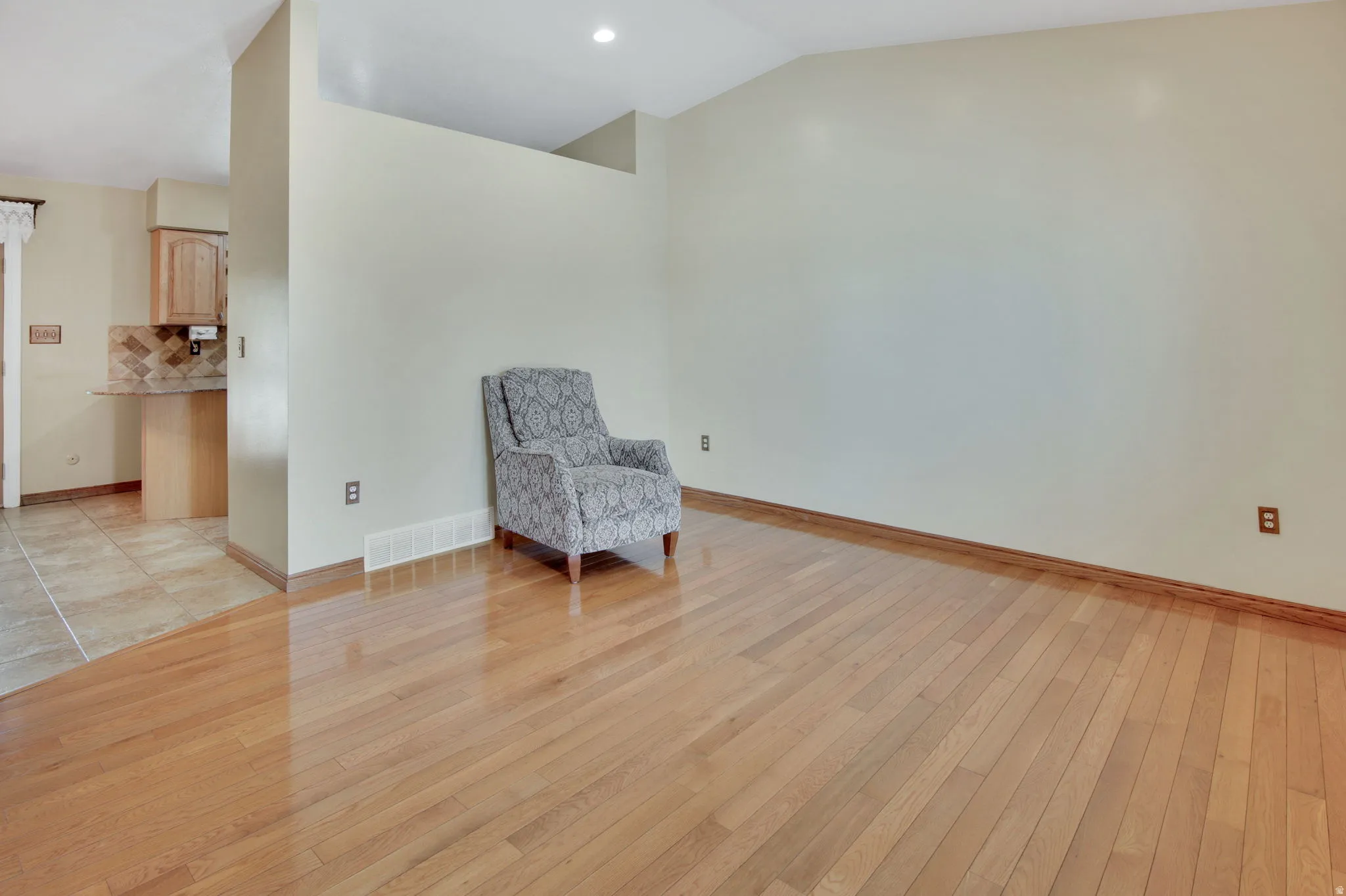 Hardwood flooring extending through the living space, complemented by a recessed light fixture
