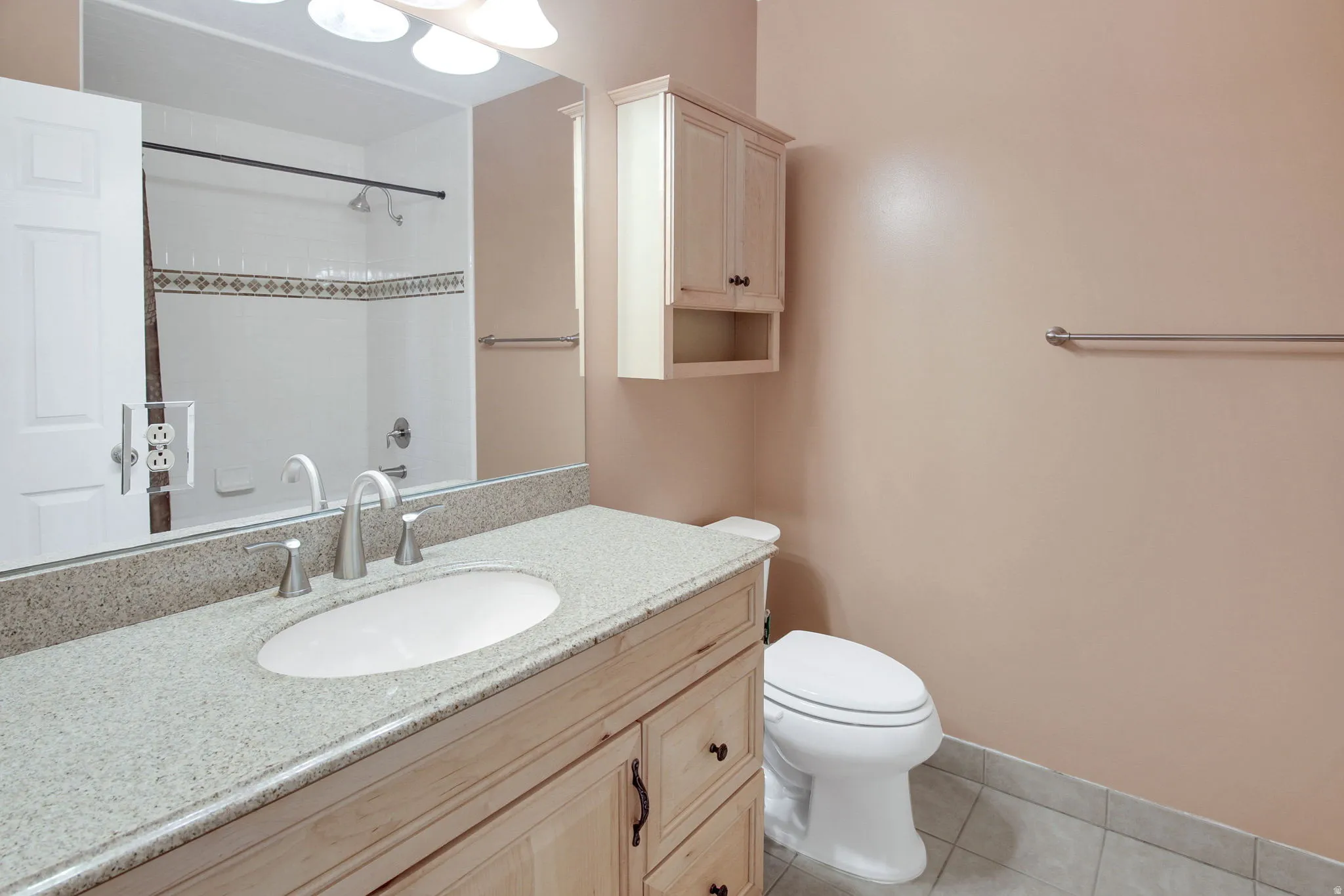 Bathroom featuring a light-toned vanity with a stone countertop and an undermount sink