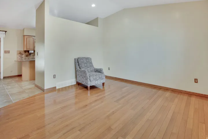 Hardwood flooring extending through the living space, complemented by a recessed light fixture