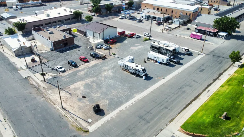 Expansive corner lot featuring asphalt and concrete paving
