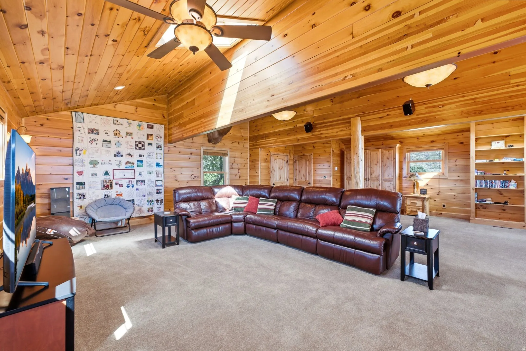 Expansive room featuring extensive wood paneling on walls and vaulted ceilings