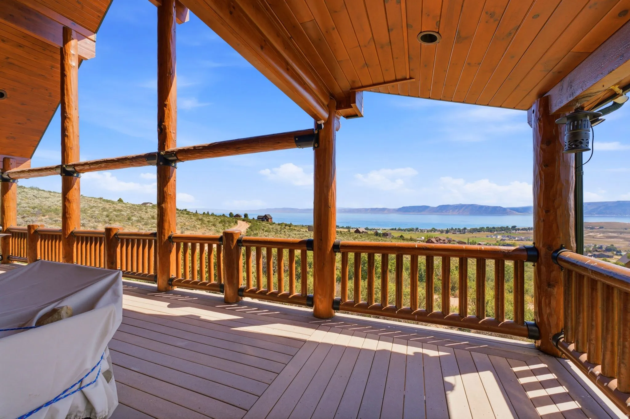 Expansive outdoor deck featuring wood-finish flooring and a wood railing system