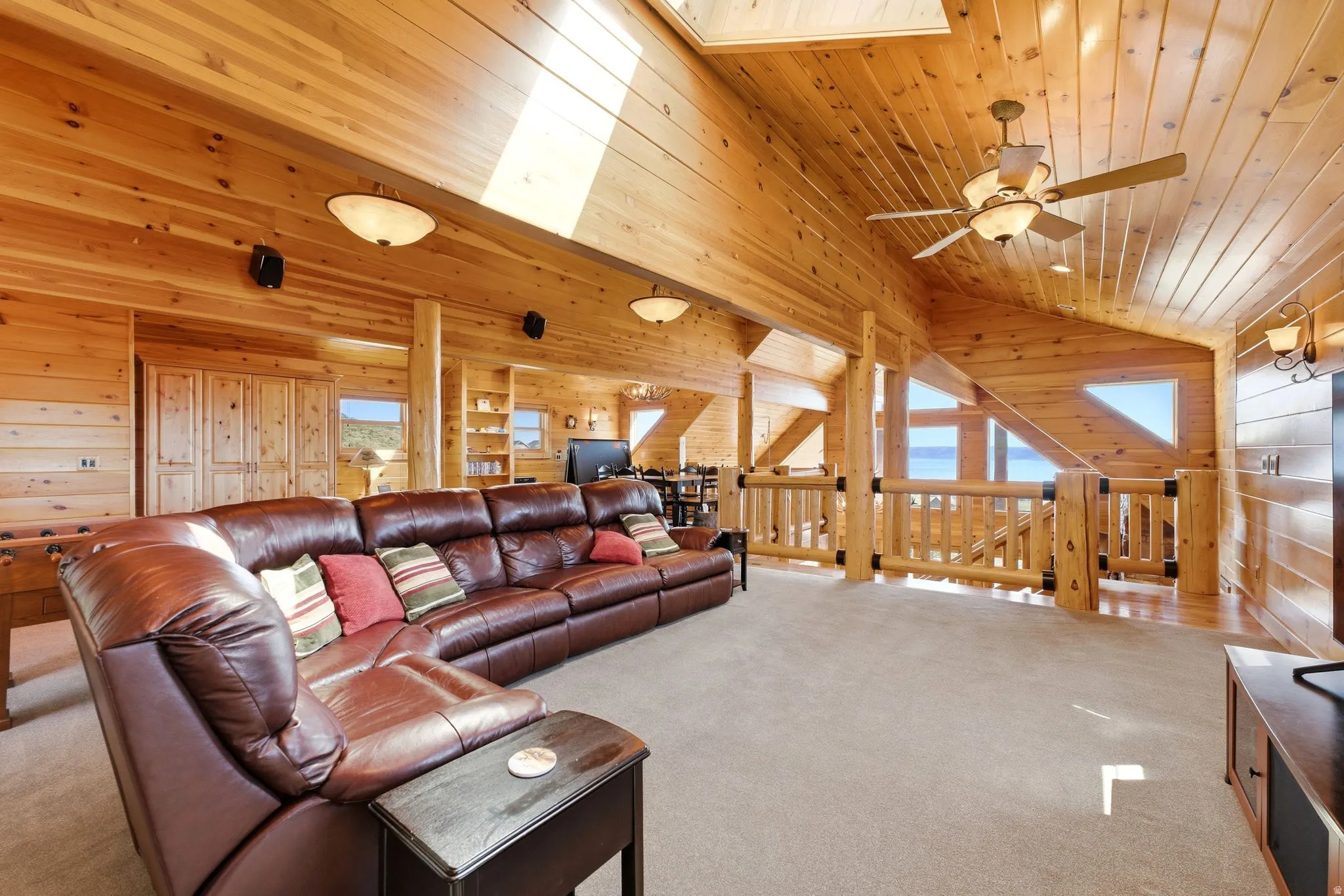 Expansive lofted space featuring extensive wood paneling and exposed wood beams