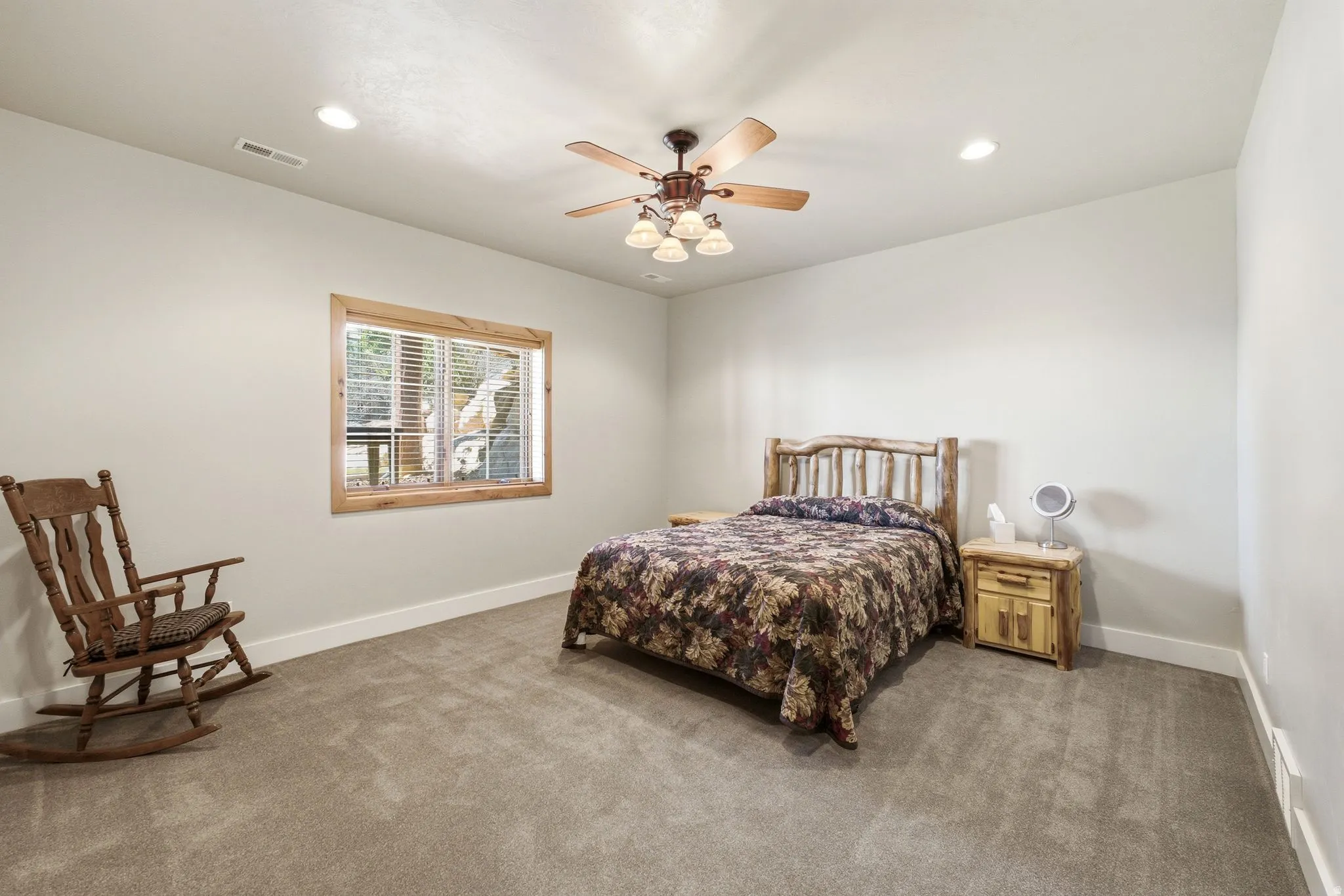 Bedroom featuring neutral wall paint, recessed lighting, a ceiling fan with light fixture, a window with wood trim, and carpeting