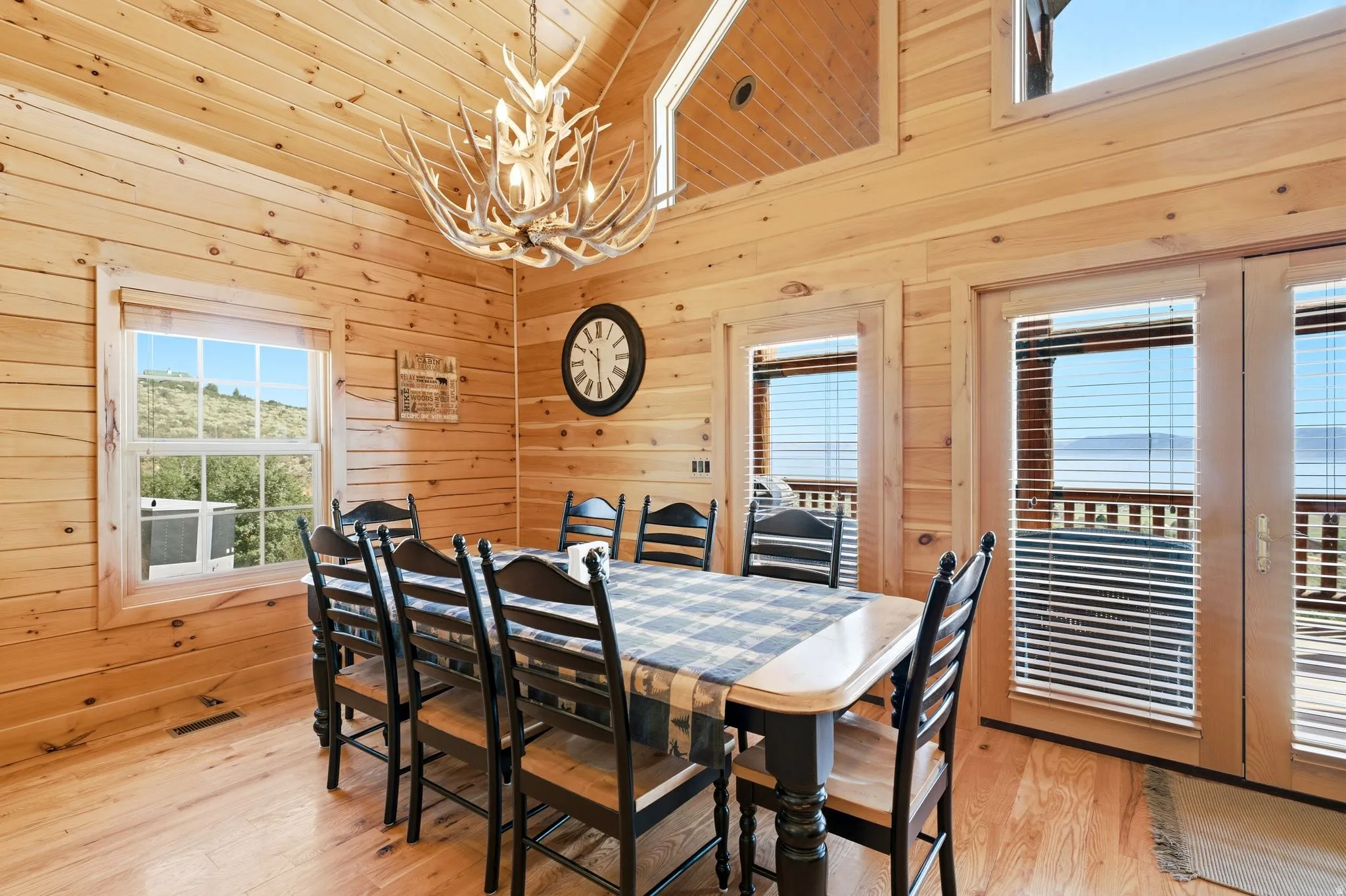 Wood-paneled room featuring a prominent antler-style chandelier