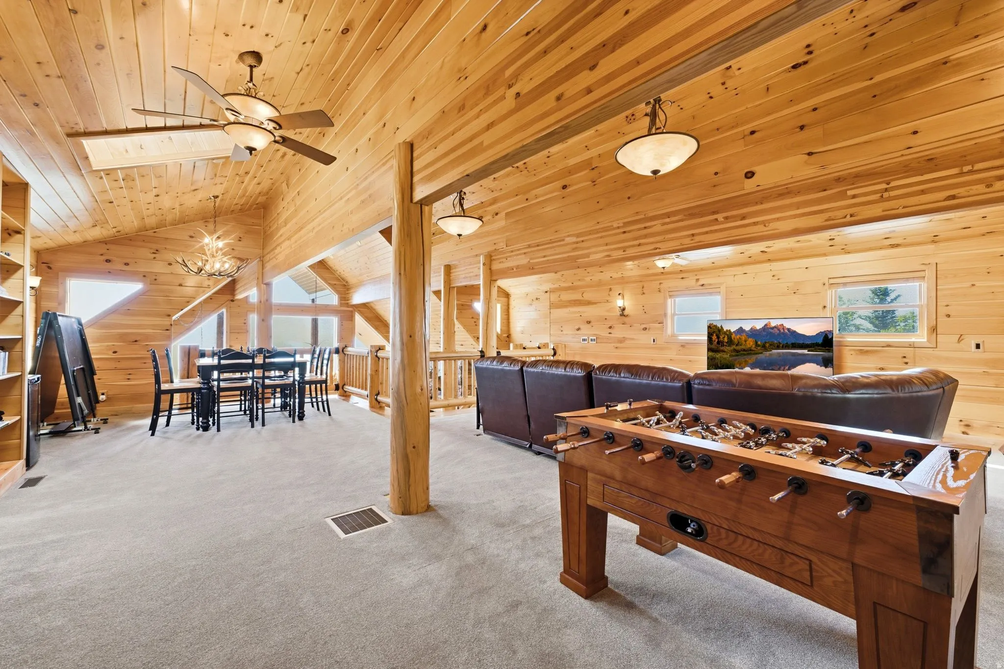 Vaulted wood-paneled ceilings with exposed wood beams, ceiling fans, and integrated lighting