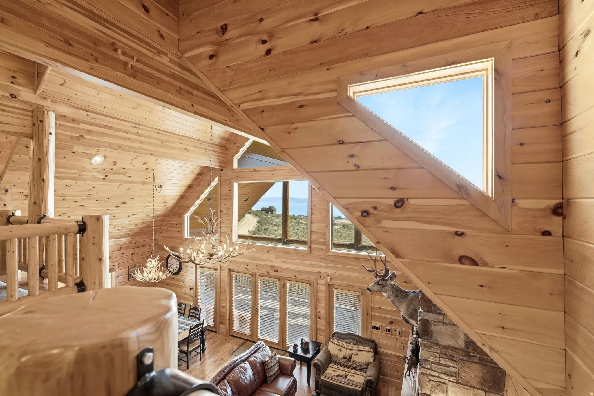 Vaulted ceiling with natural wood paneling, featuring triangular and rectangular windows