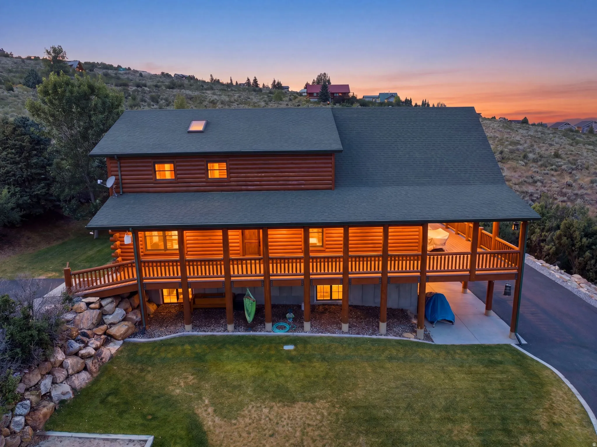 Log-style residence with a prominent elevated deck, a gabled roofline, and a skylight