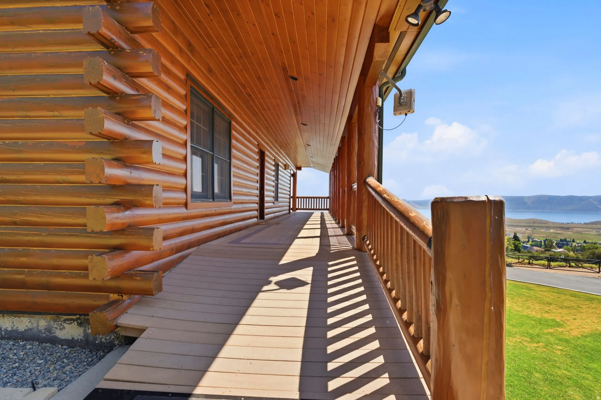 Expansive wood-finish deck with a custom wood railing, featuring a ramped entry