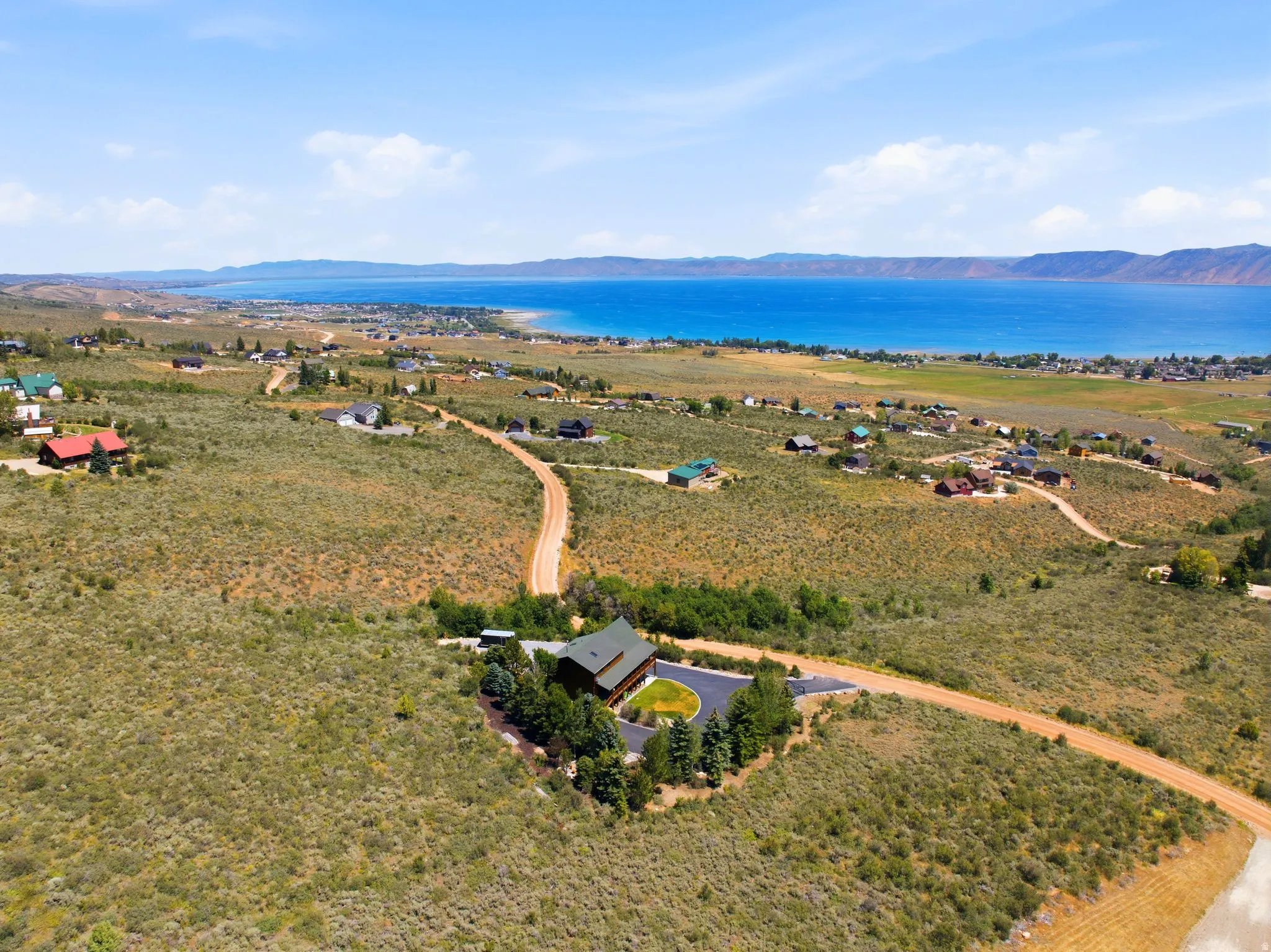Expansive aerial perspective showcasing a residential property nestled within a landscape of natural vegetation