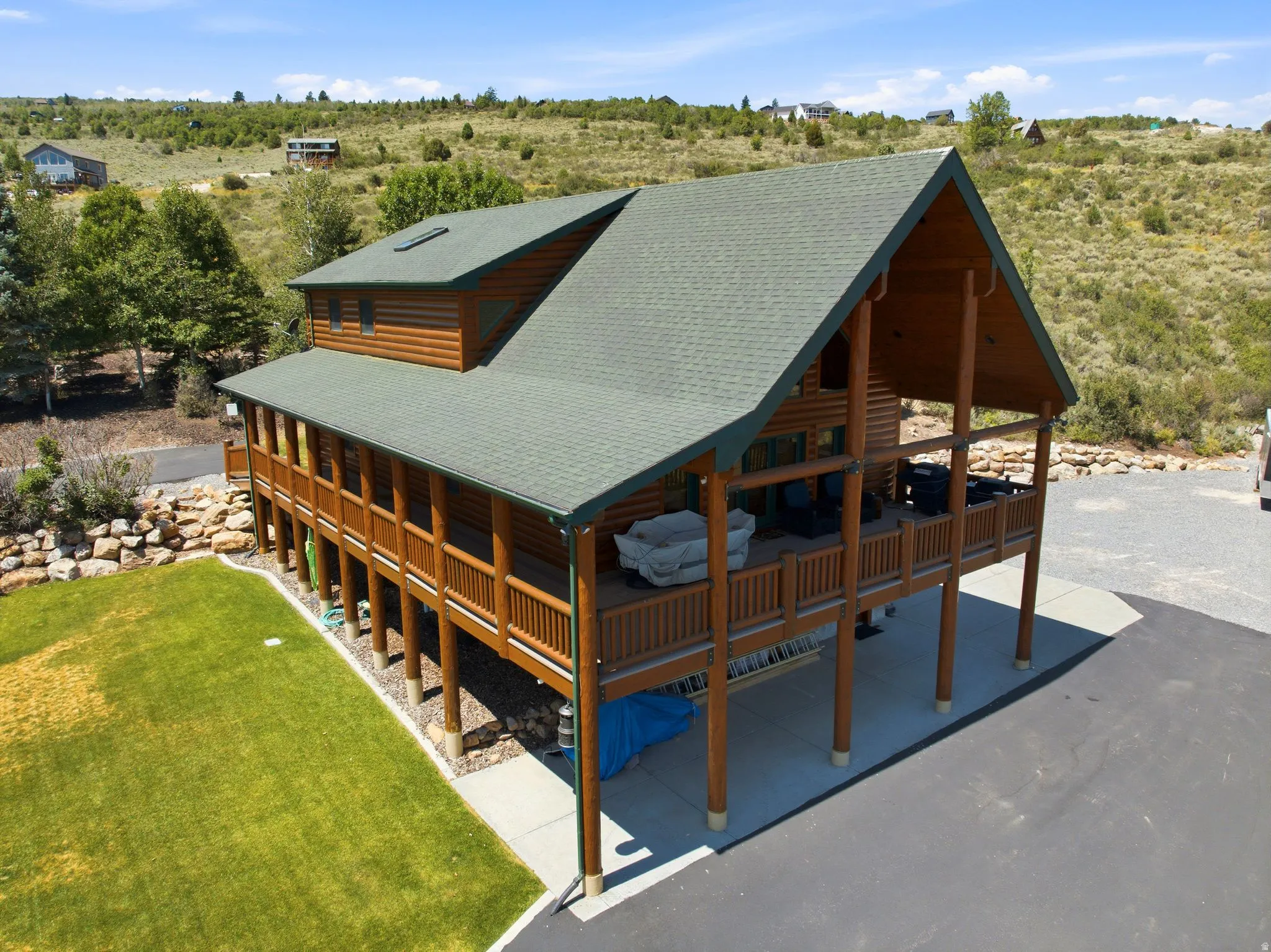Log-sided residence featuring a prominent covered porch extending across the front and side