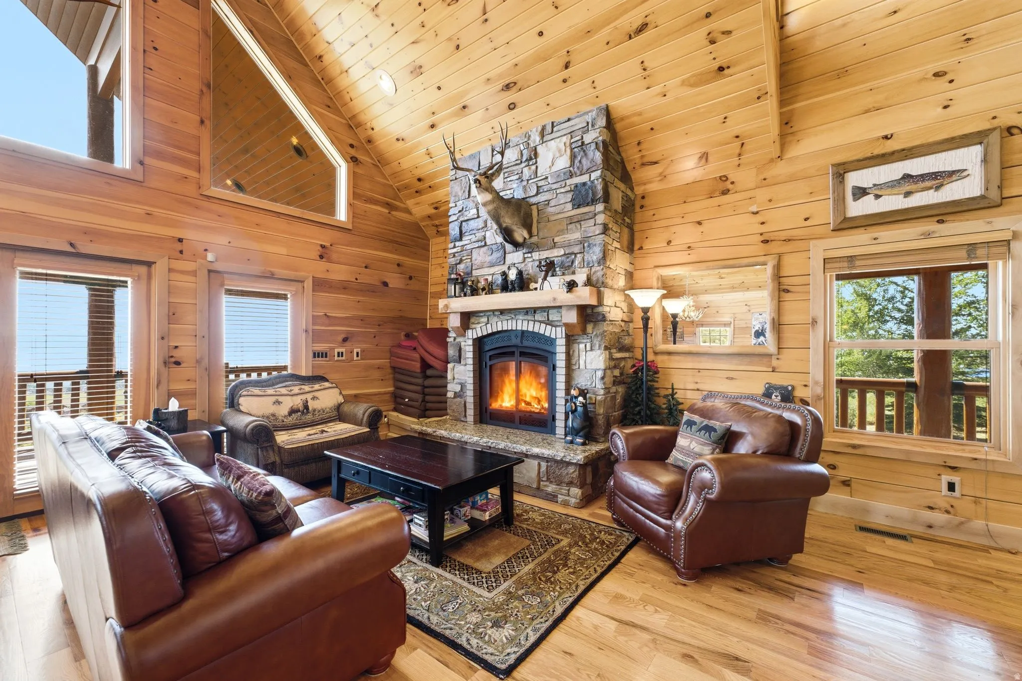 Vaulted wood-paneled ceiling and walls complement the stone fireplace