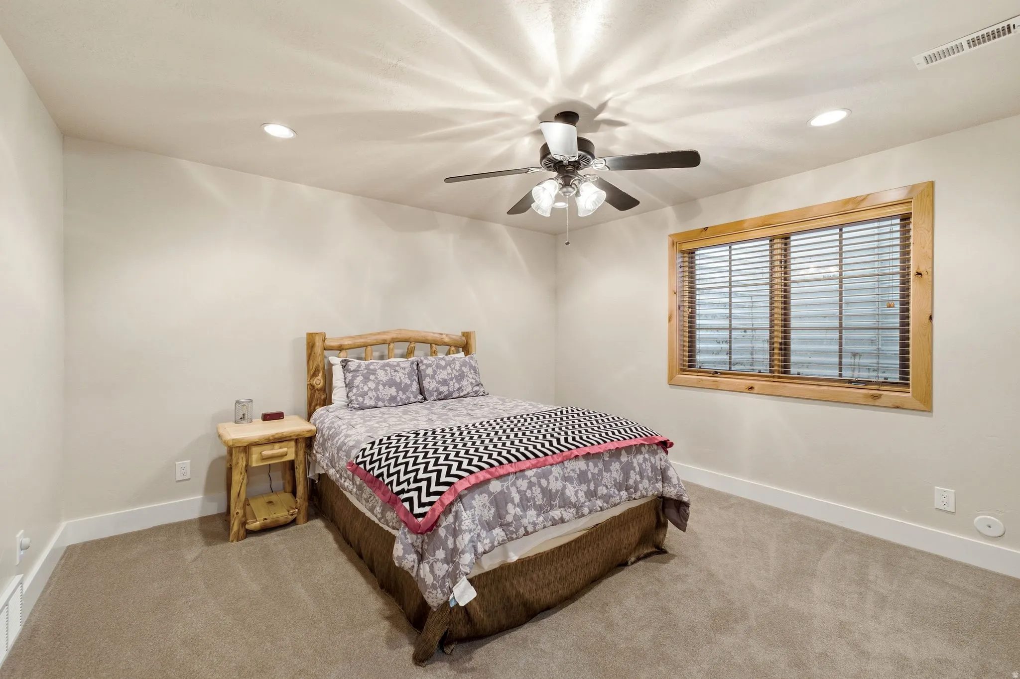 Carpeted room featuring a ceiling fan with integrated lighting, recessed lighting, and a wood-trimmed window