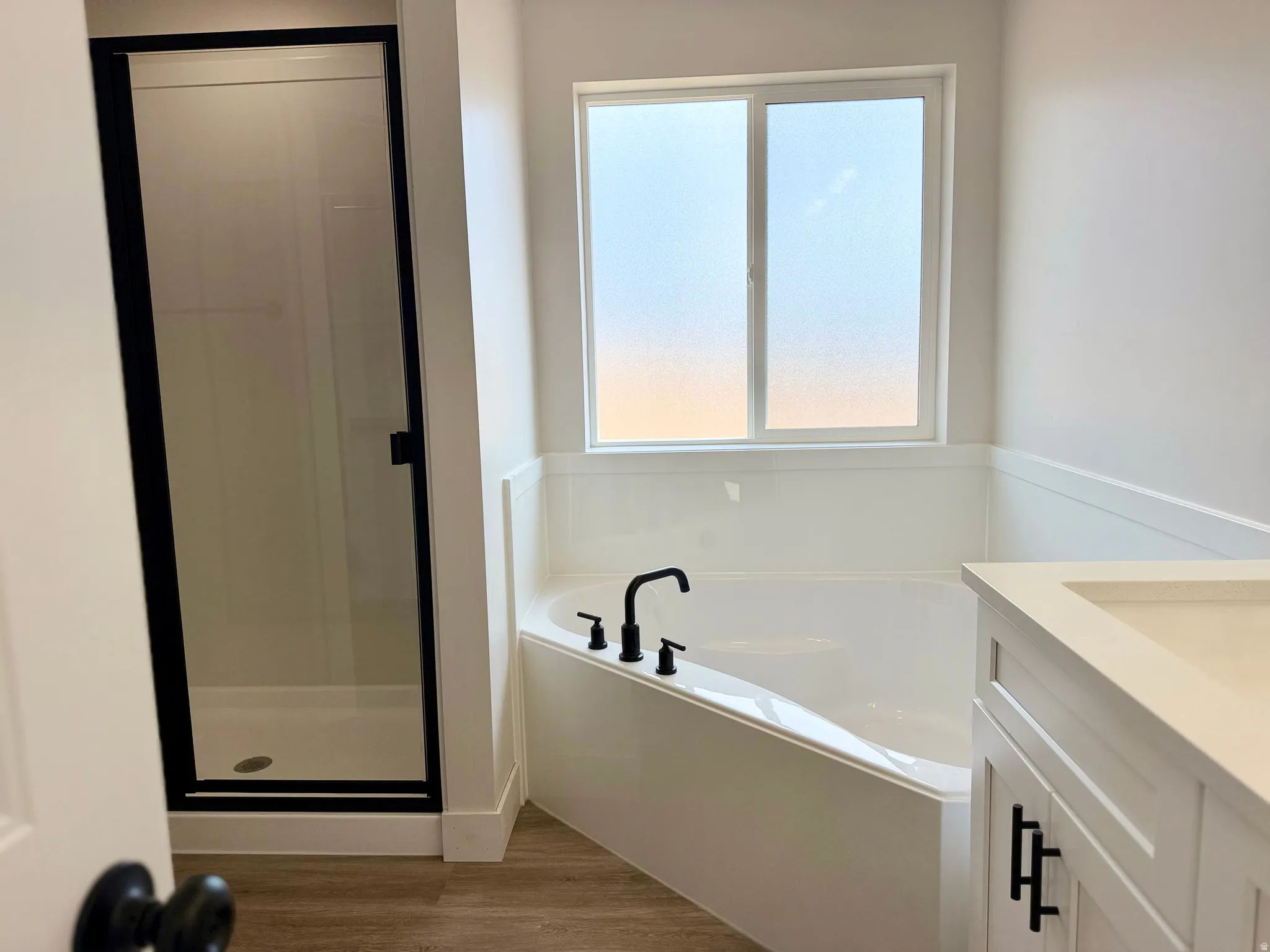Primary ensuite bathroom with dual vanities, oversized corner tub and separate shower