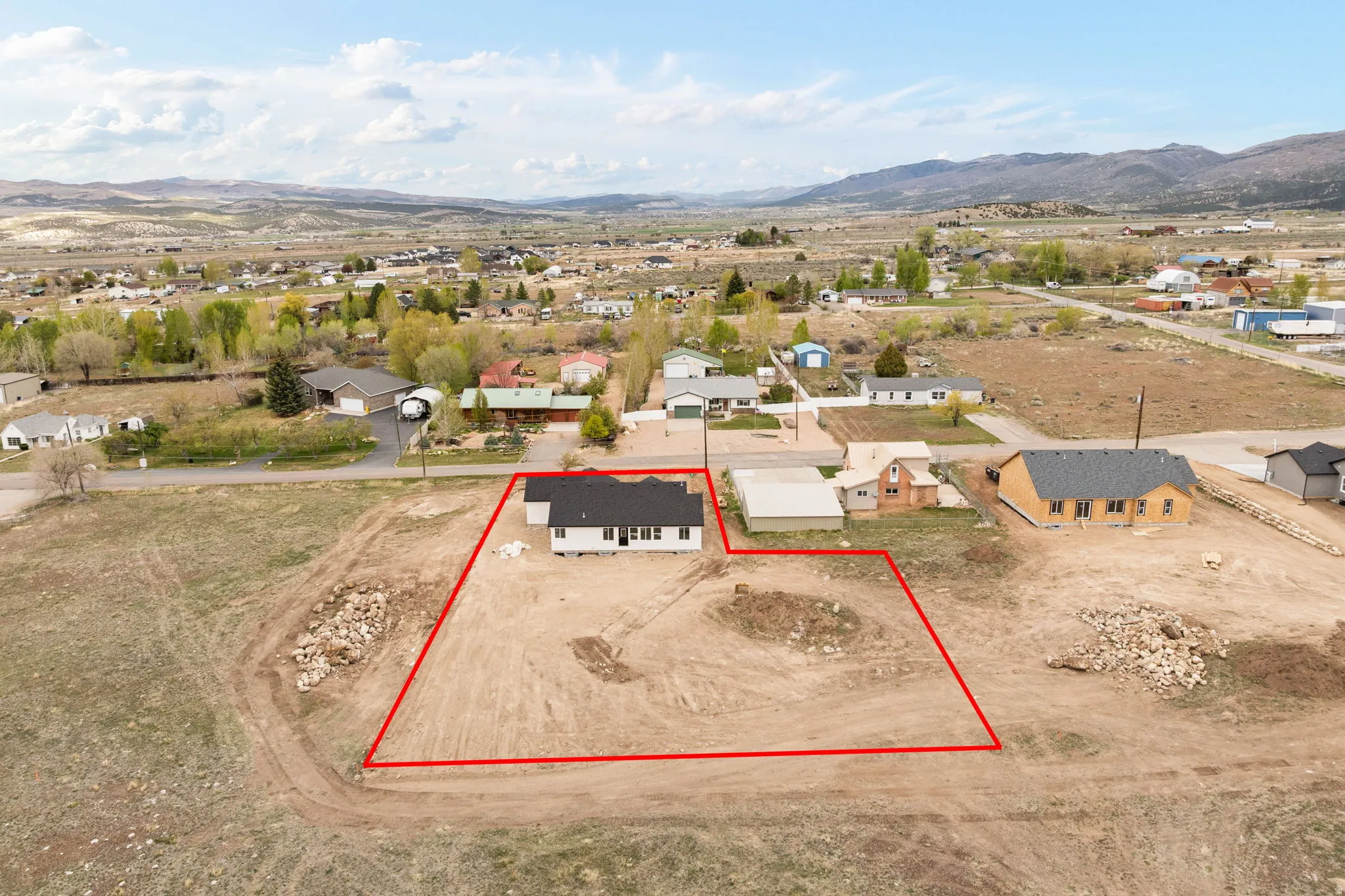 Newly constructed single-story residence with a dark roof and light-colored siding, situated on a spacious, undeveloped lot