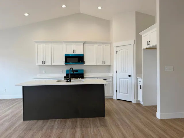 Kitchen with two-tone custom cabinetry with soft-close. Center island sink and dishwasher and stainless steel appliances