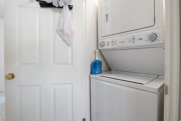 Stacked laundry unit with white appliances