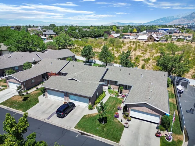 Residential structures featuring brick exteriors, attached garages with white doors, and grey shingle roofs