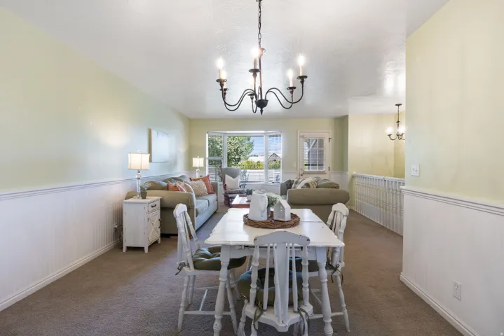 Open concept living and dining areas featuring wainscoting and neutral wall tones