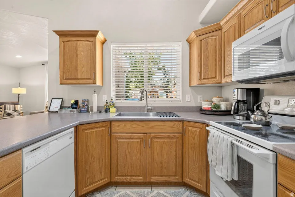 Kitchen with wood cabinetry, gray countertops, and a window above the sink