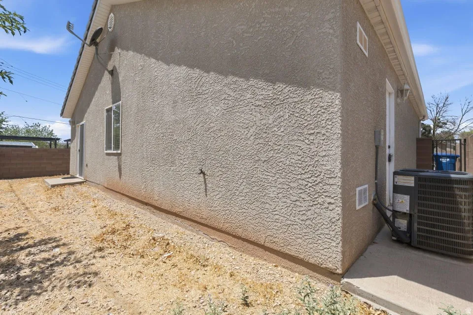 Stucco exterior with a rear entry door and a single-pane window