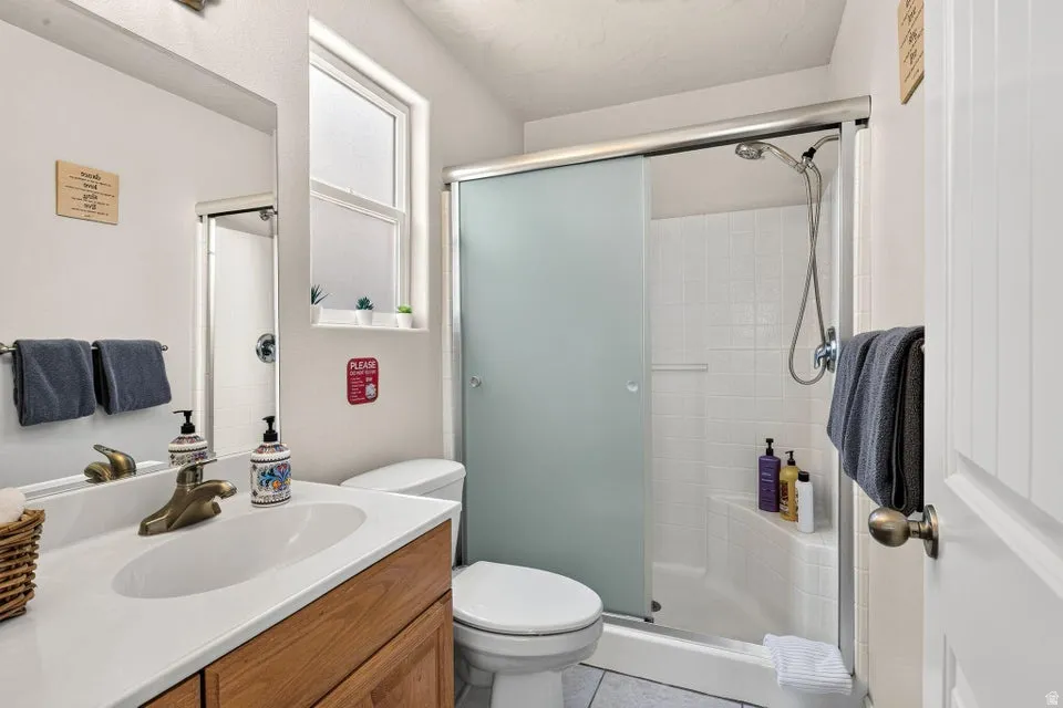 Bathroom featuring a wood-finish vanity with an integrated white sink, bronze-finish faucet, and a large wall-mounted mirror