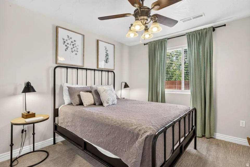 Carpeted room featuring a ceiling fan with integrated lighting, a window with blinds, and light-toned wall finishes