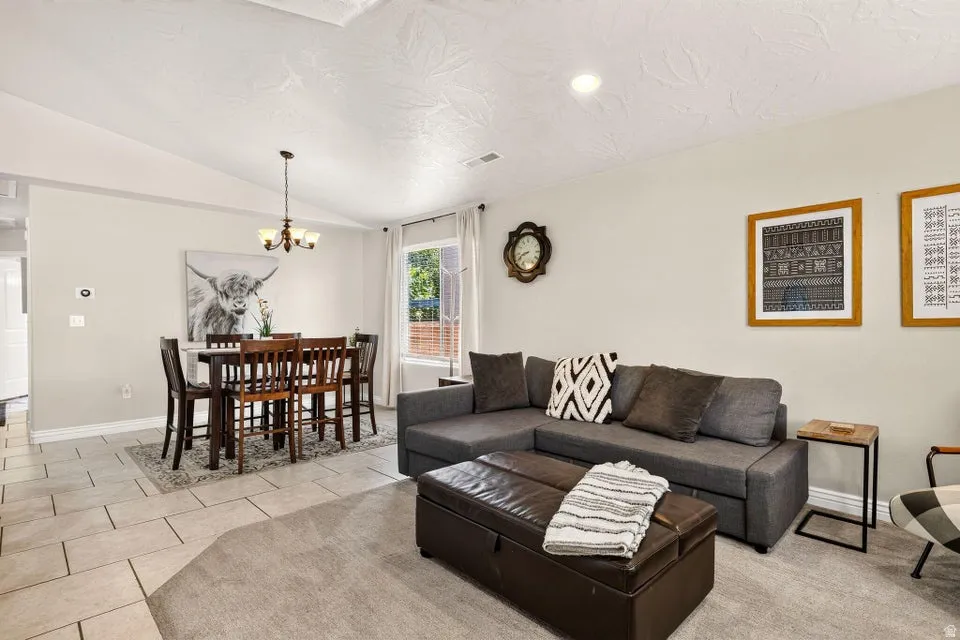 Combined living and dining areas featuring vaulted ceilings and recessed lighting