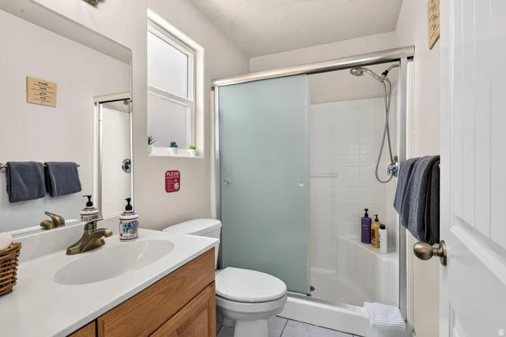 Bathroom featuring a wood-finish vanity with an integrated white sink, bronze-finish faucet, and a large wall-mounted mirror