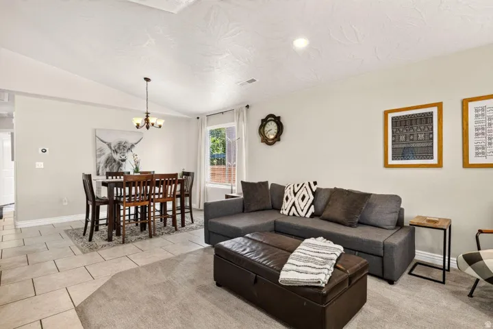 Combined living and dining areas featuring vaulted ceilings and recessed lighting