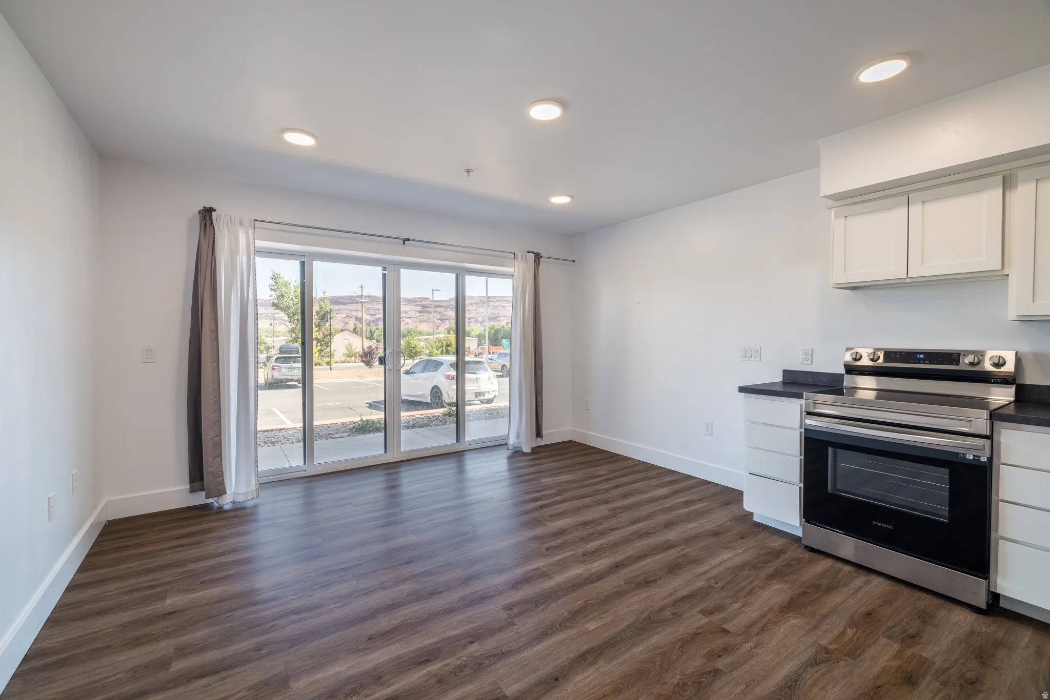 Open concept living area featuring wood-finish flooring, recessed lighting, and a full-light sliding glass door