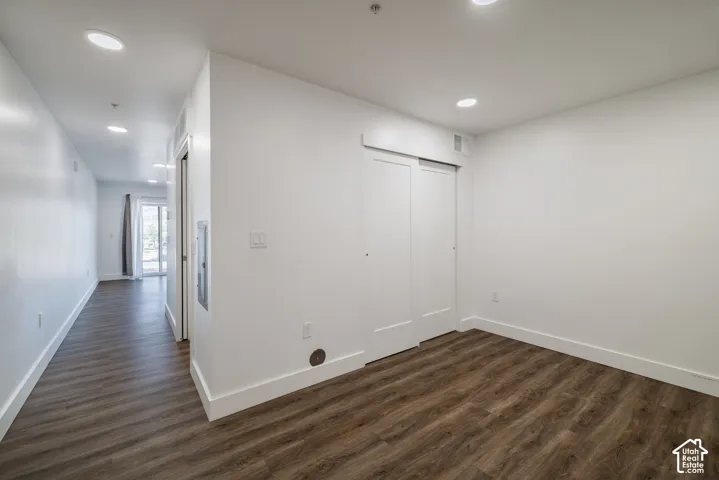 Spacious room featuring wood-finish flooring, recessed lighting, and a sliding door closet