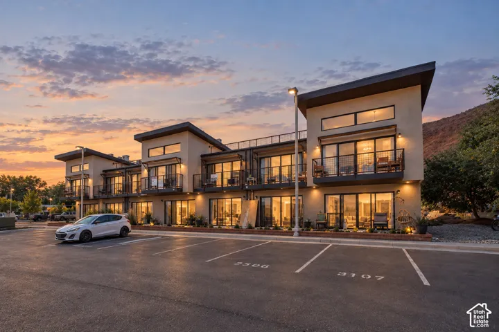 Modern architectural style featuring multiple balconies, large windows, and an exterior of stucco and dark trim
