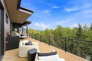 Expansive outdoor deck featuring a protective overhang, recessed lighting, and durable rail system