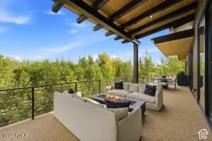 Expansive outdoor living area with a stone-finish surface, a built-in fire feature, and a slatted wood ceiling
